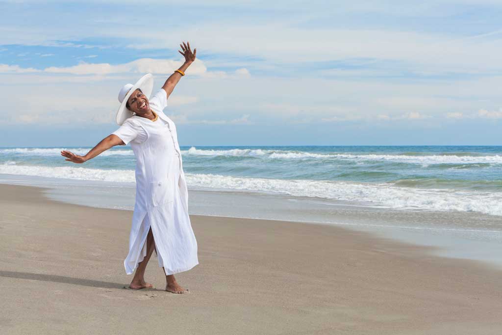 happy woman on the beach feeling positive