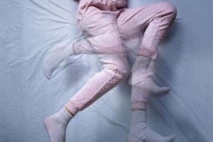 woman in bed with restless leg syndrome