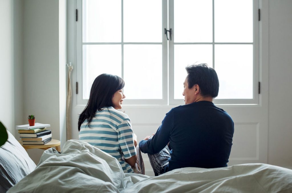 couple in bed having honest conversation