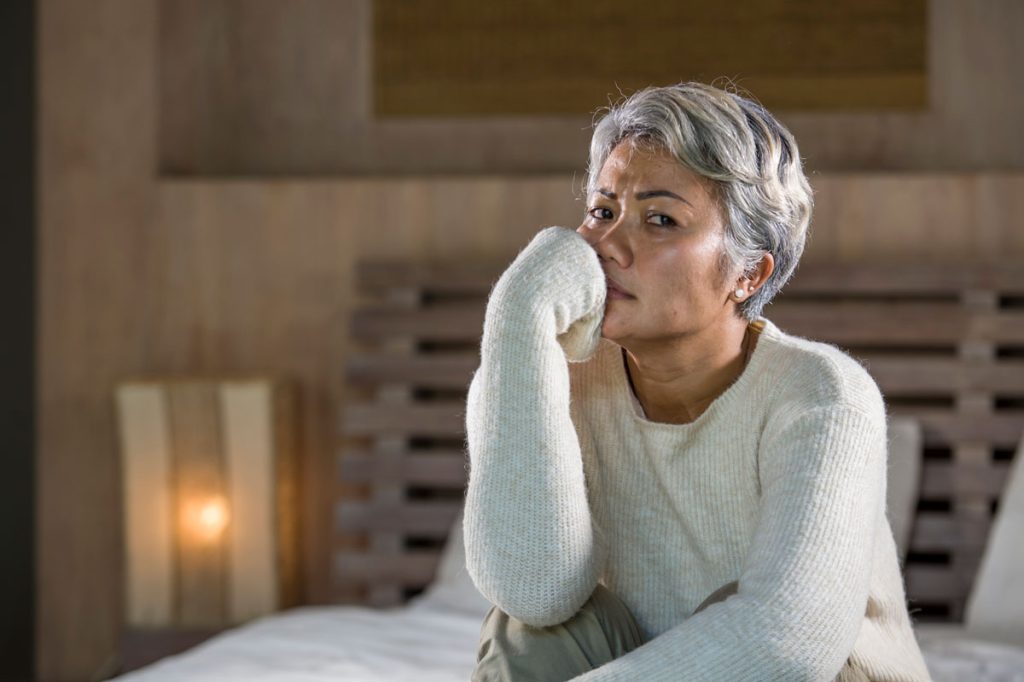 depressed and sad woman sitting on bed