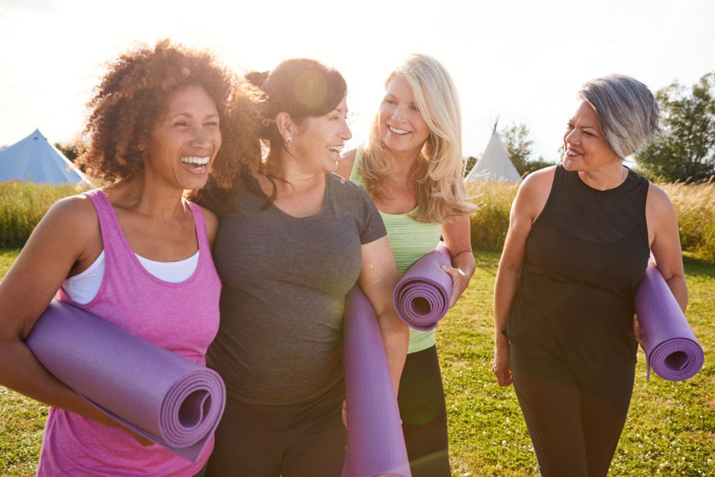diverse group of happy women leading healthy lifestyle with yoga mats