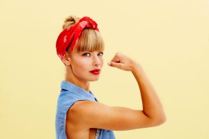 woman flexing muscle turning anger about feminism into a positive force