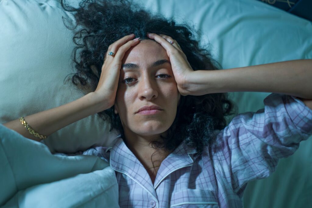woman with hands on head awake in middle of hte night