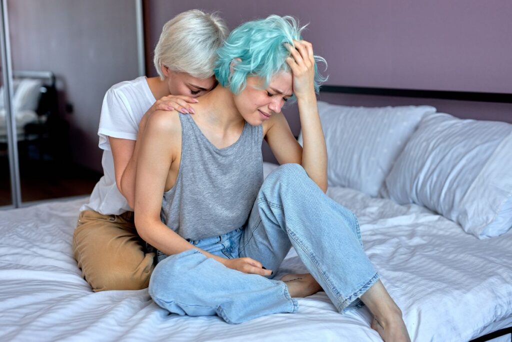Lesbian couple comforting each other in bed