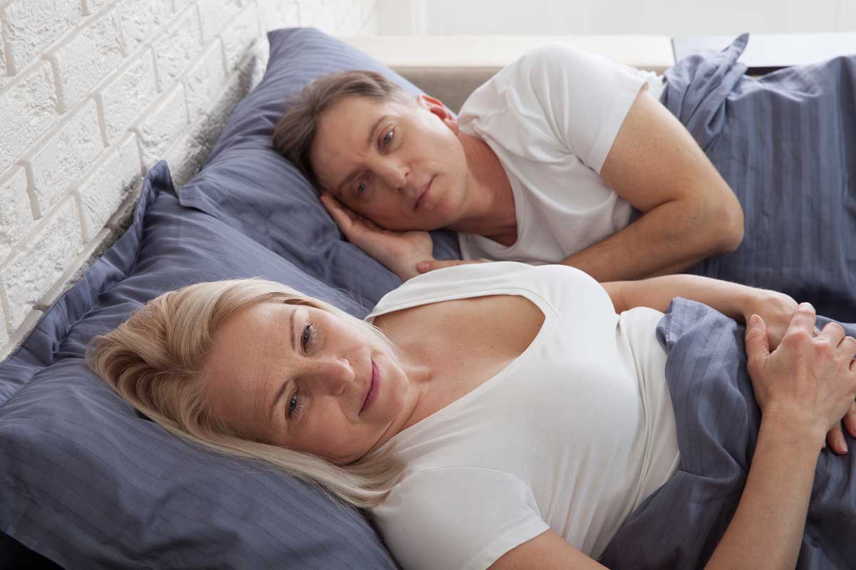 woman lying in bed worried about painful sex