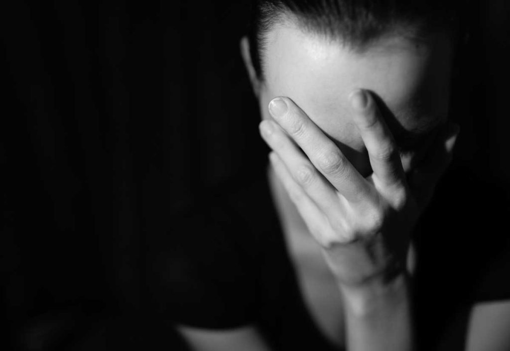 woman with hands over face from anxiety and depression