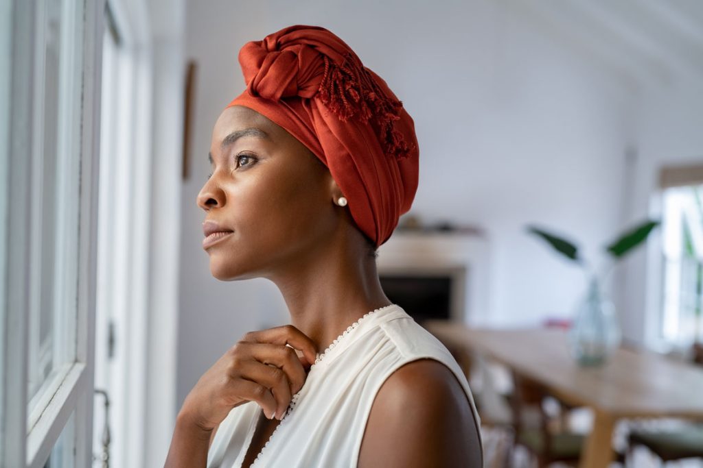 African American woman thinking and looking out window