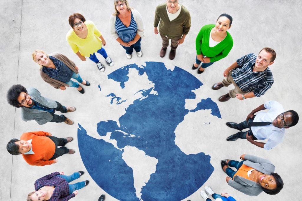 diverse people standing around globe