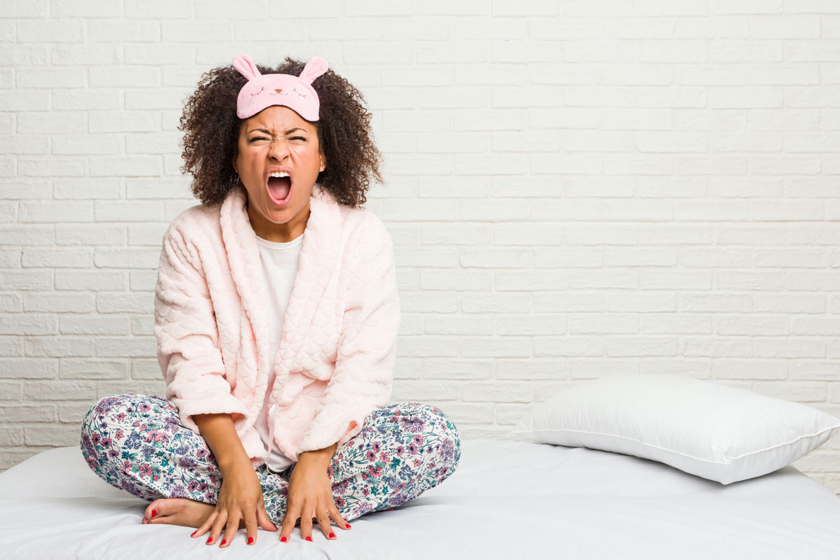 tired woman yawning in bed