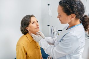 Woman having her thyroid checked by doctor