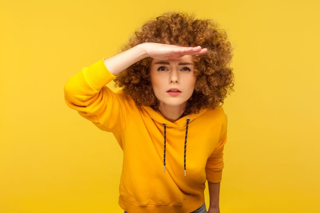 woman with hand on forehead looking ahead to future