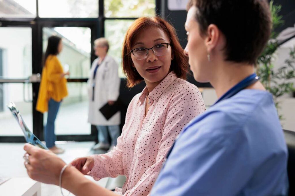 Asian woman looking at osteoporosis xray with doctor