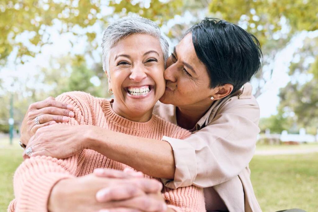 LGBTQIA women kissing and hugging