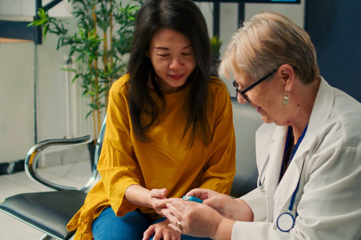 doctor testing a woman's blood sugar for diabetes