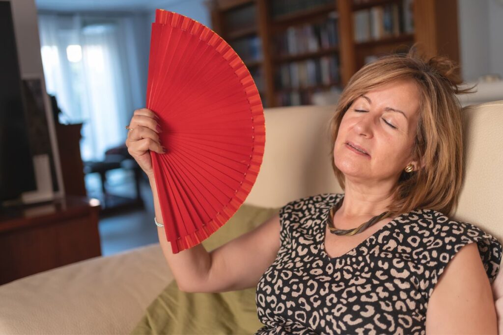 Woman fanning herself to relieve hot flash