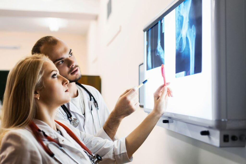 Doctors looking at xrays to determine if there's a hip or spine fracture