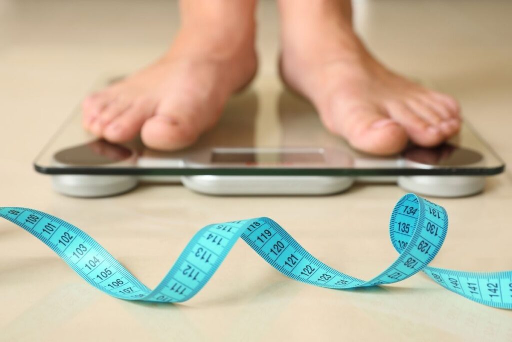 Woman standing on scale worried about weight gain