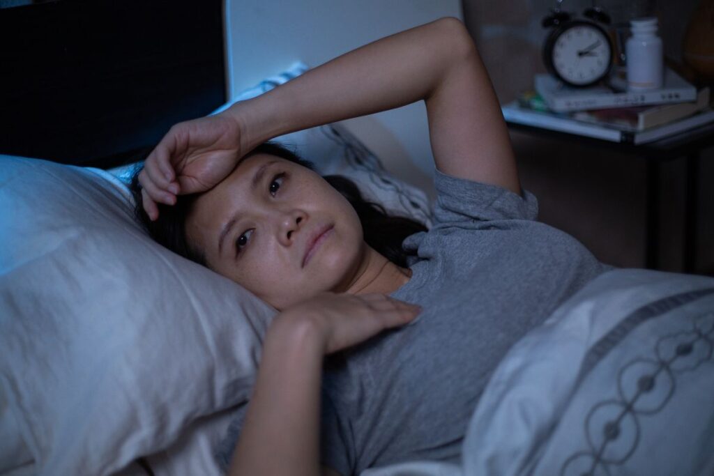 Woman suffering from insomnia awake at night