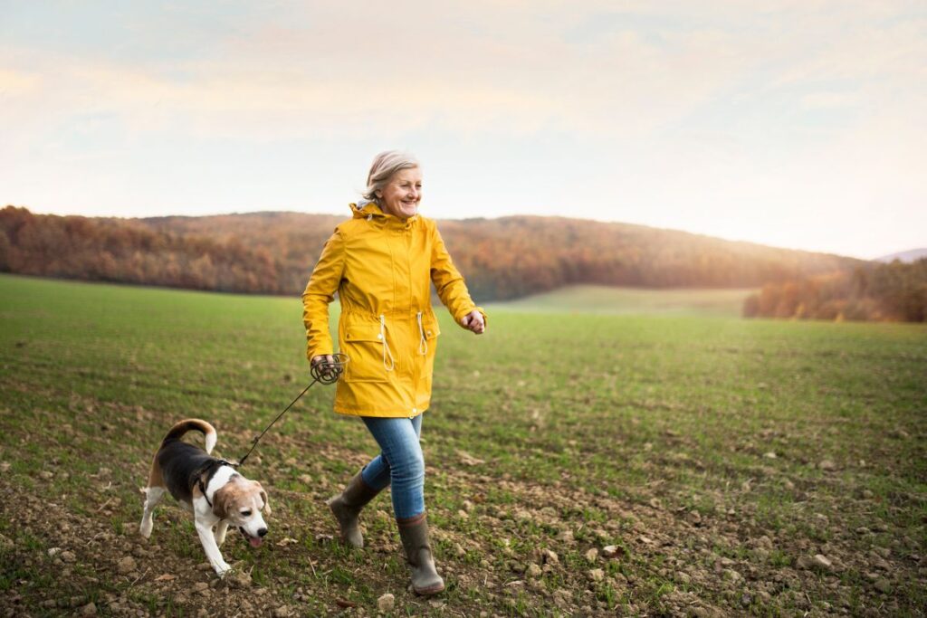 woman running with her dog in a field