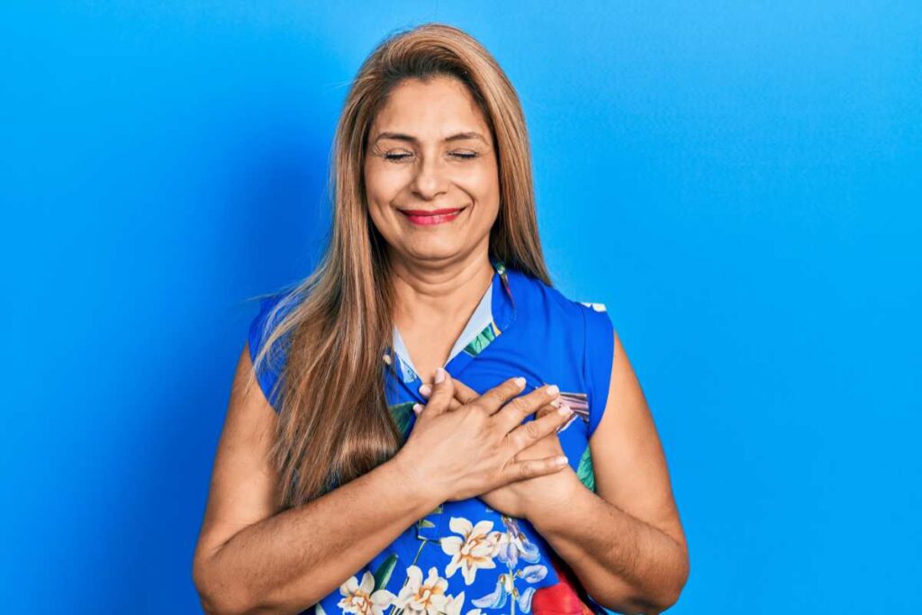 Happy Hispanic woman holding her heart