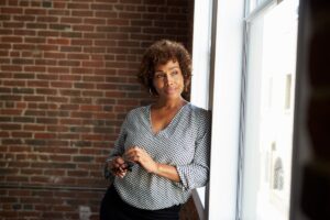 Black menopausal woman starting out the window