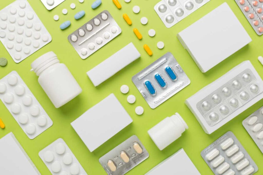 Pill packs laid out on a green background