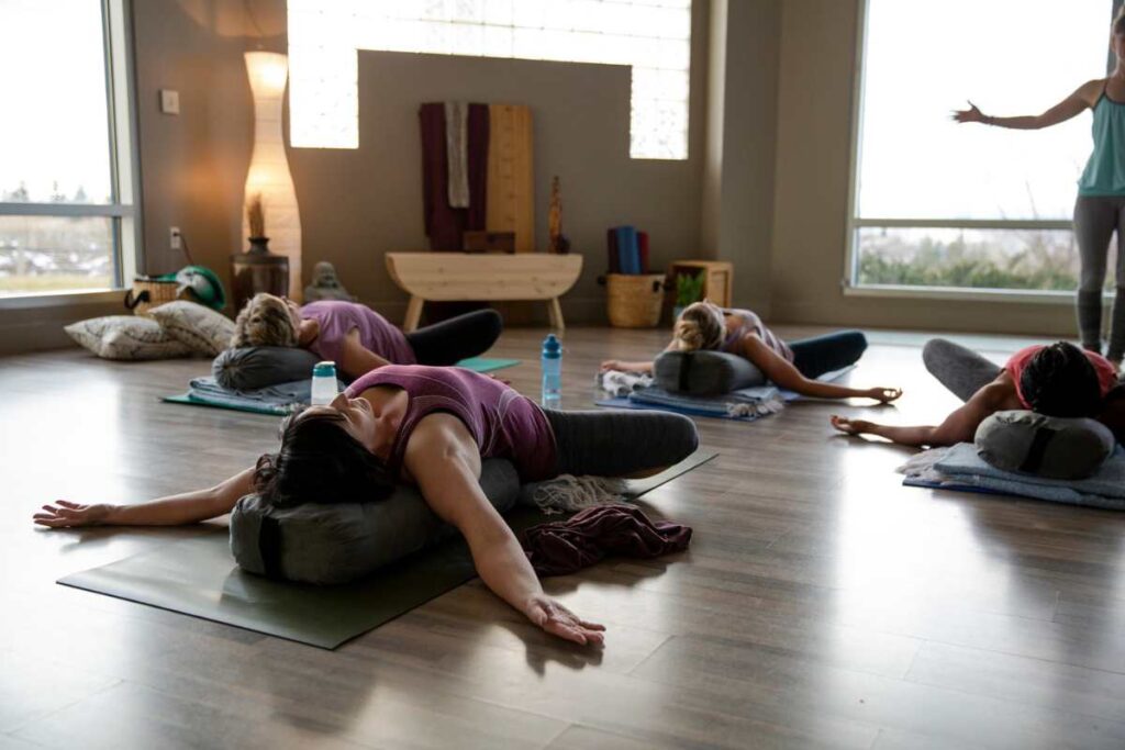 Women laying down practicing restorative yoga