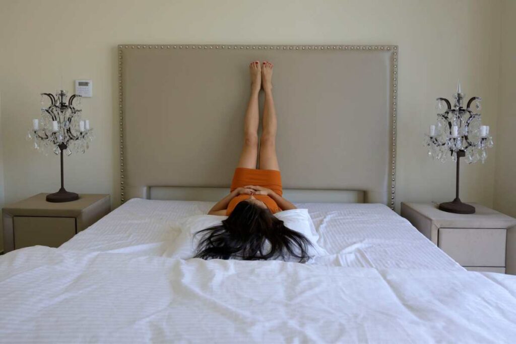 yoga pose in bed with legs up the wall