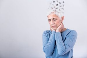 Menopausal woman feeling forgetful with hands on face and puzzle pieces coming out of brain