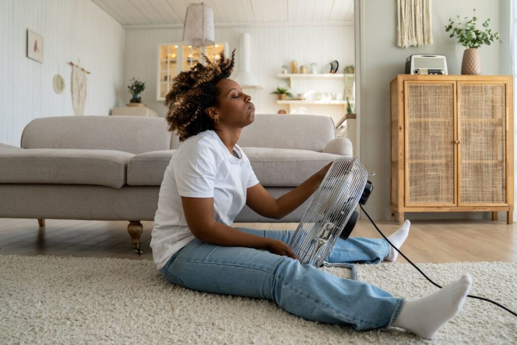 Black woman with a fan to relieve a hot flash