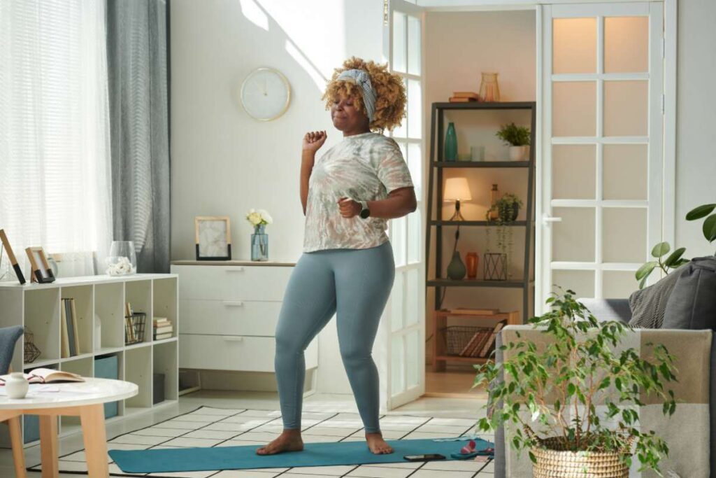 Black woman moving her body dancing in her house