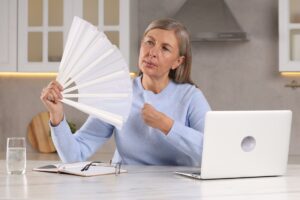 woman using fan during hot flash